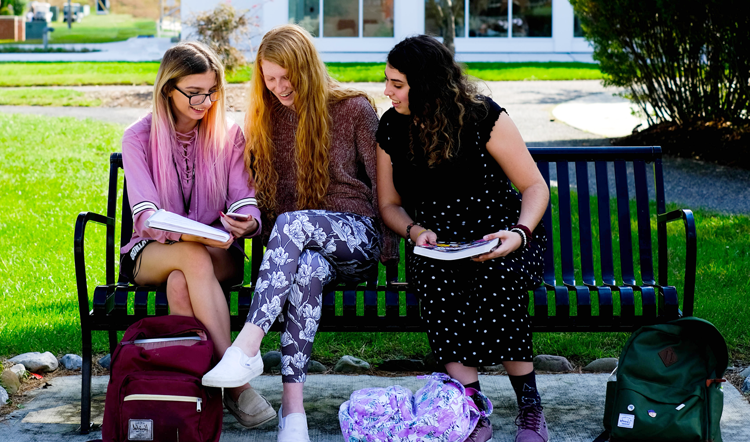 yj1001.net three female students studying on a bench on camp at Ocean County College